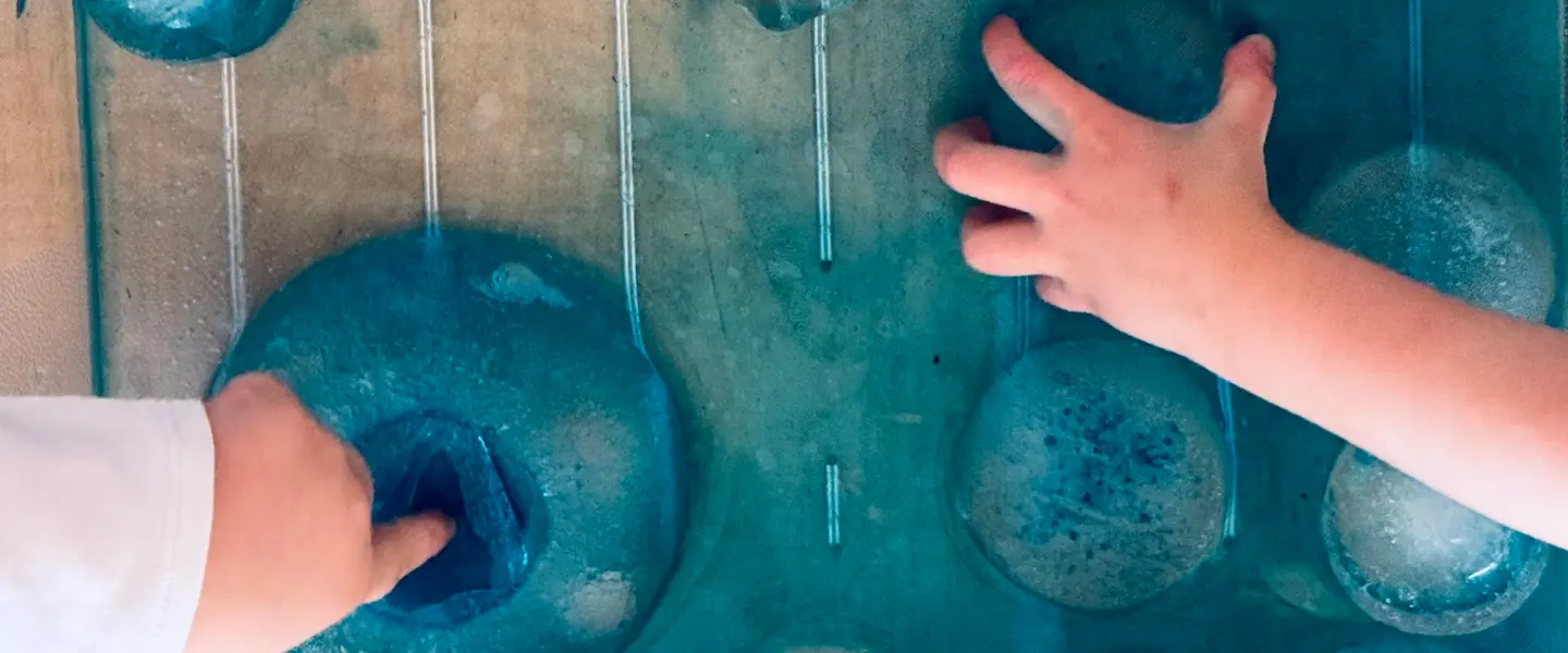  Two kid hands playing with blue paint