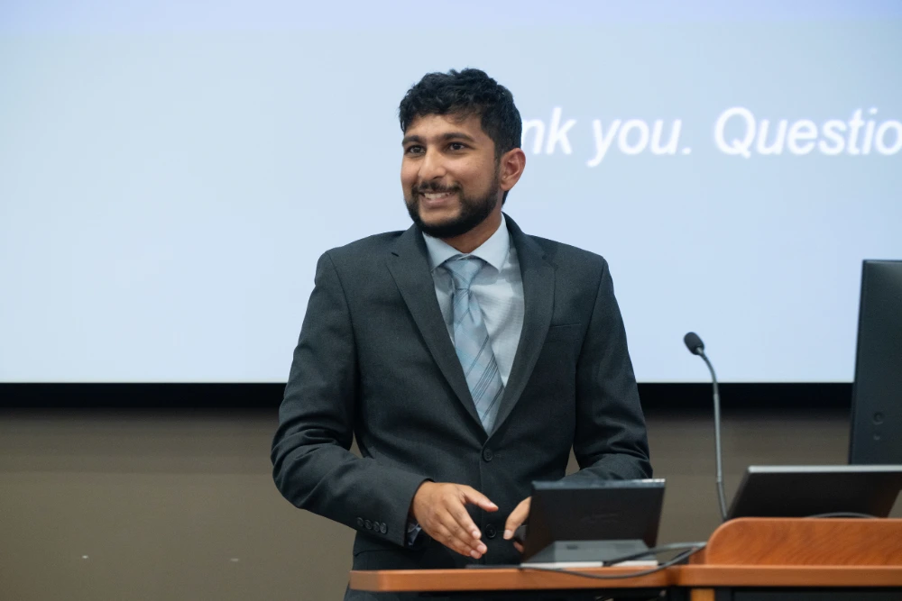 Student researcher Zain Hussain smiles and takes questions following his presentation on non-linear visual field progression in glaucoma.