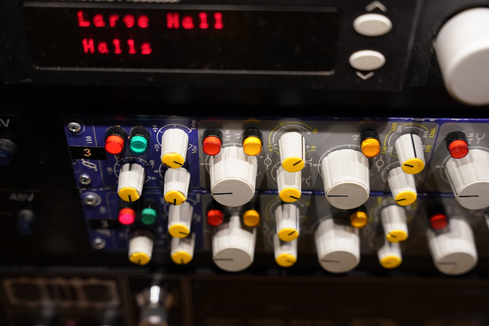 Professional audio effects unit with multiple white knobs, colored buttons, and a digital display showing 'Large Hall' reverb.