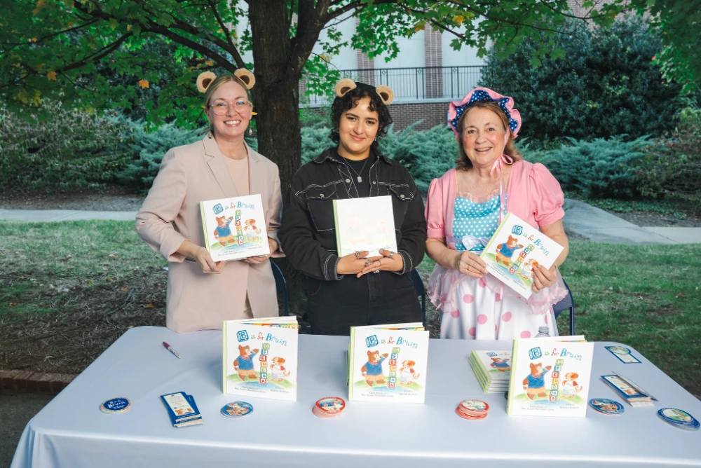 Davis, Ibrahim and Jones holding book