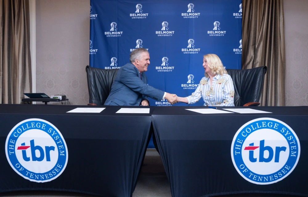 Belmont University and TBR representatives shake hands, formalizing an education partnership.