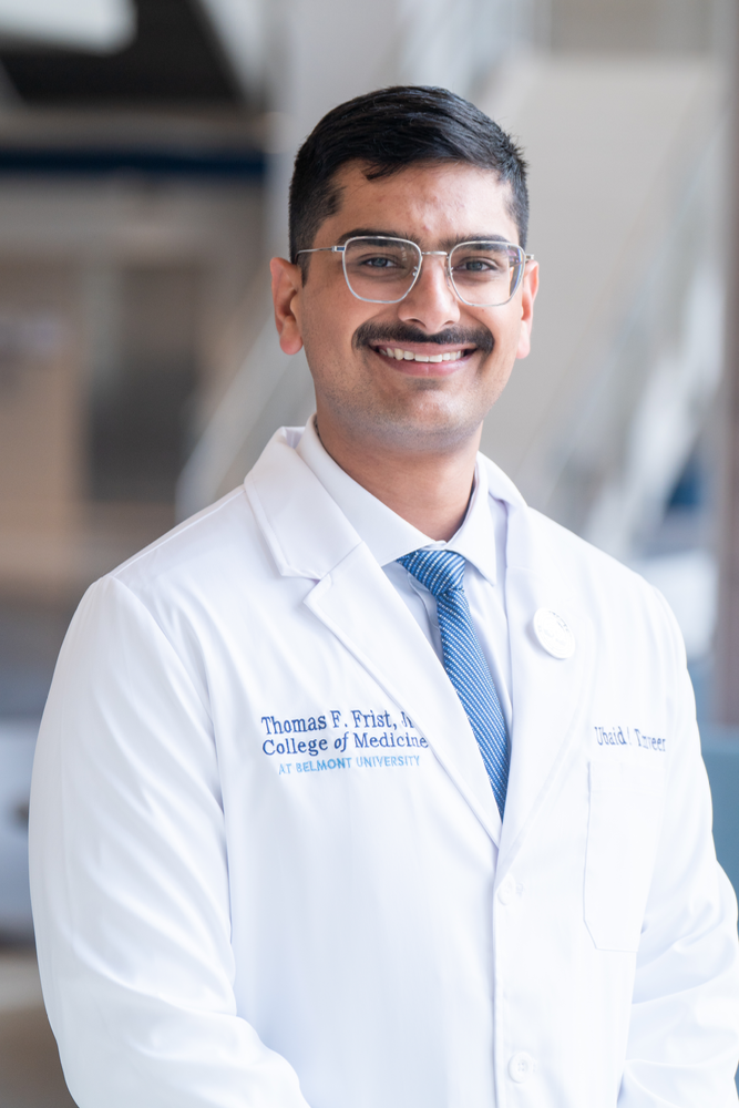 Ubaid Tanveer, medical student at Belmont University's Thomas F. Frist, Jr. College of Medicine, smiling in a lab coat.