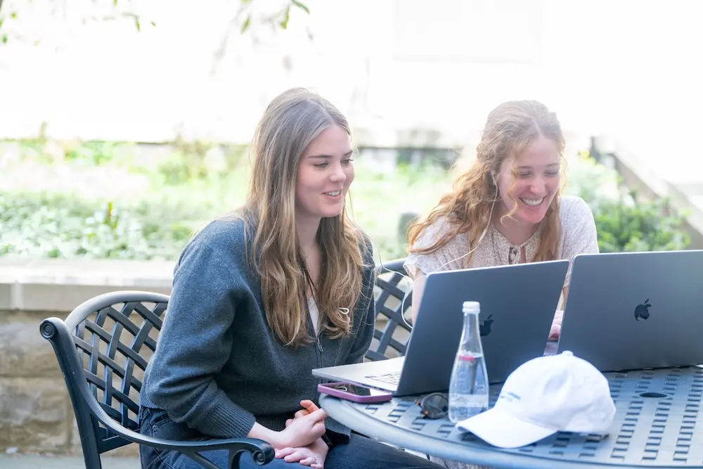 Two people with laptops outside