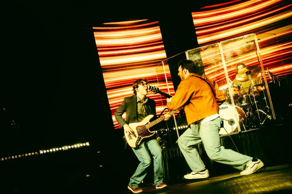 Two students playing guitars on stage