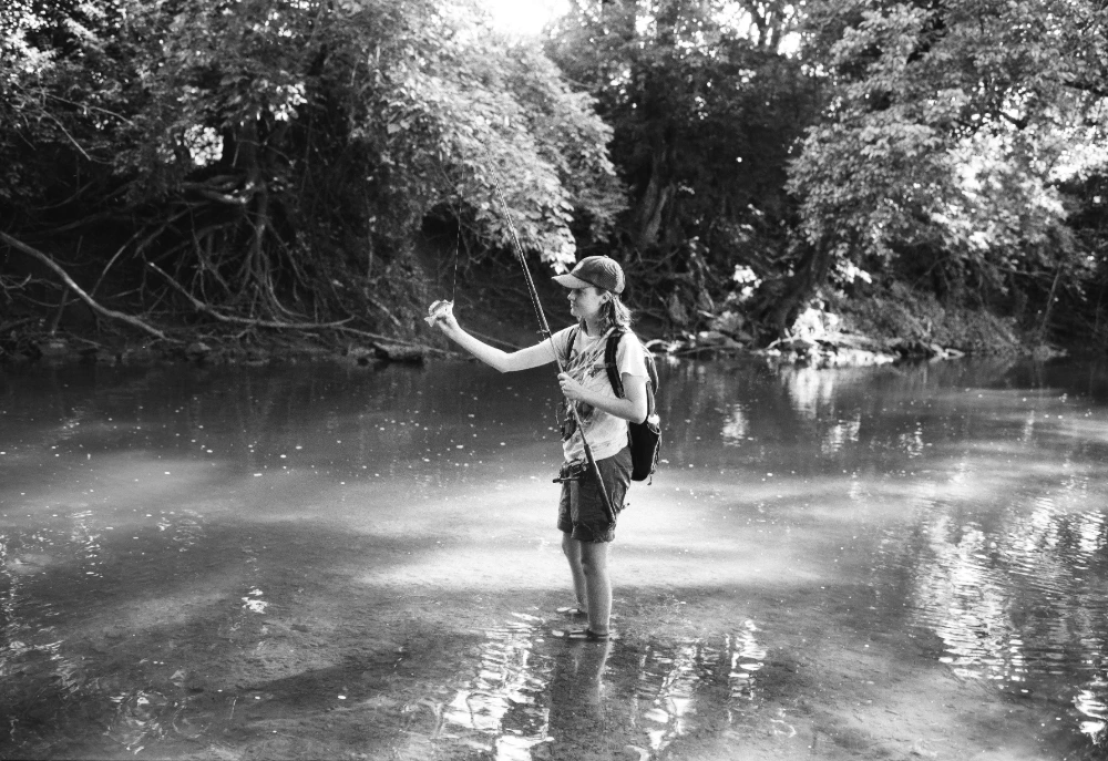 A person fishing in a stream