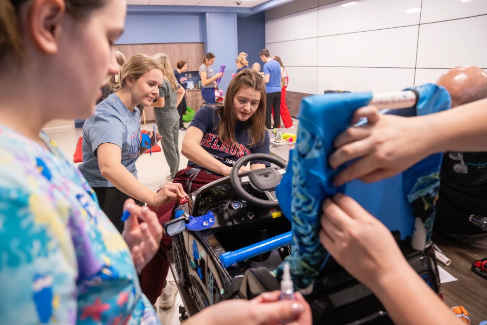 Students working on a custom car as a team