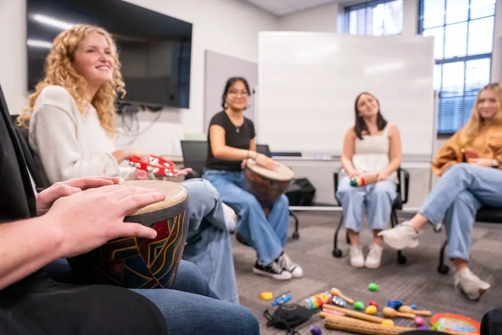 people playing bongo drums in a music therapy session