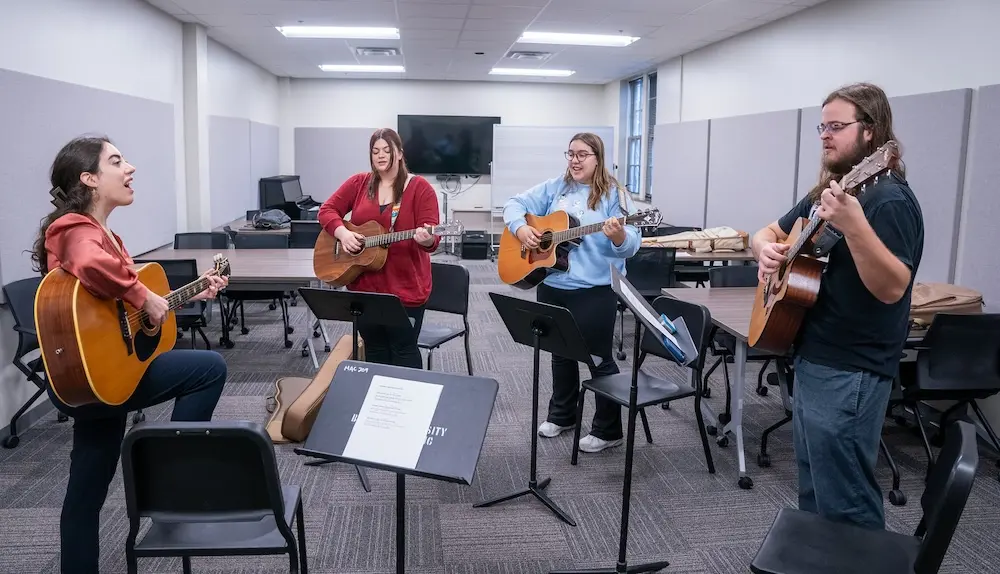 four people playing guitars