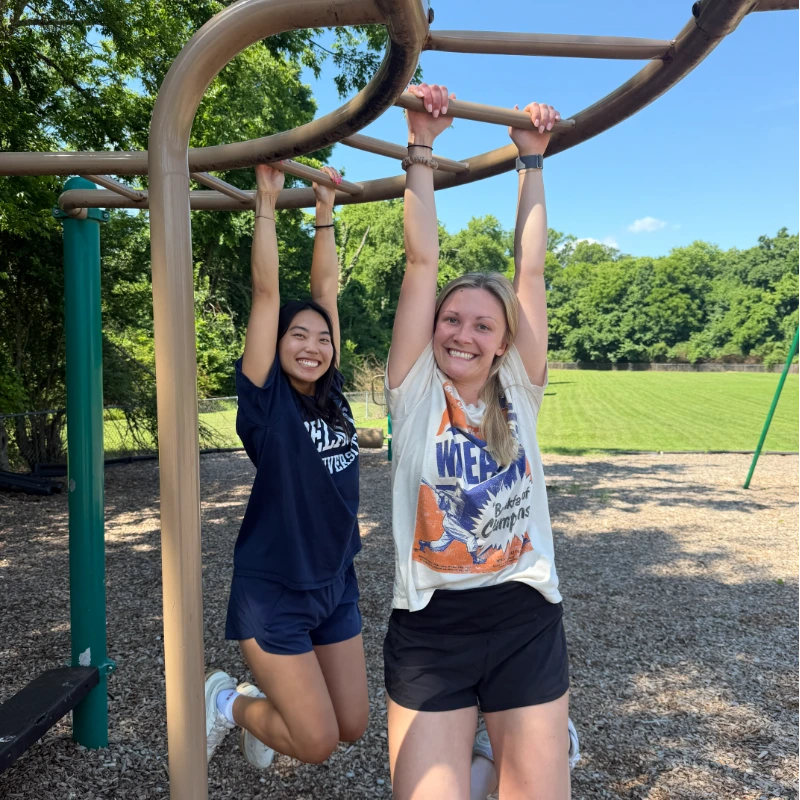 Students demonstrating therapeutic playground activities, such as hanging from monkey bars to build strength