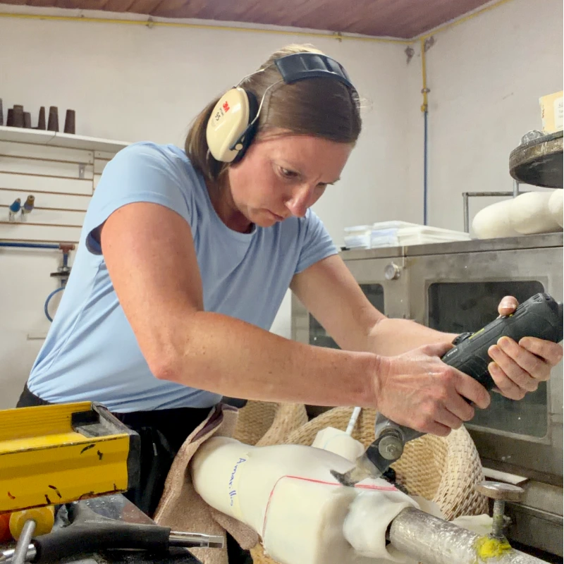 Kim, carving prosthetic limbs with a power saw in Ecuador