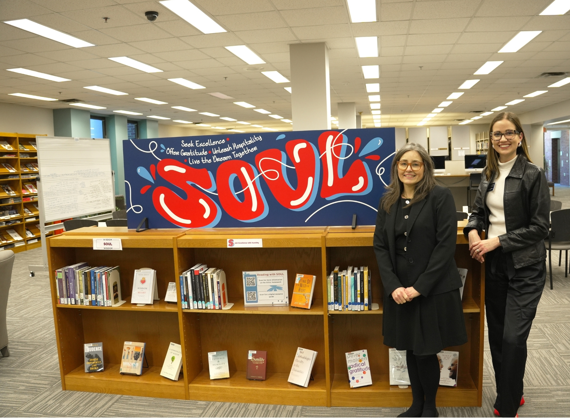 Sue and Caroline smiling with the SOUL reading display