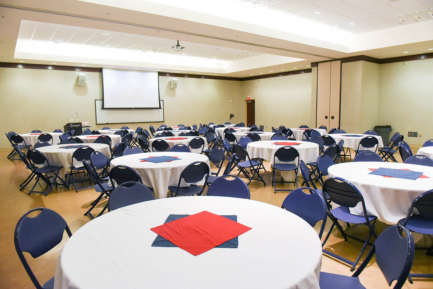 Beaman Conference Room with empty round tables and chairs