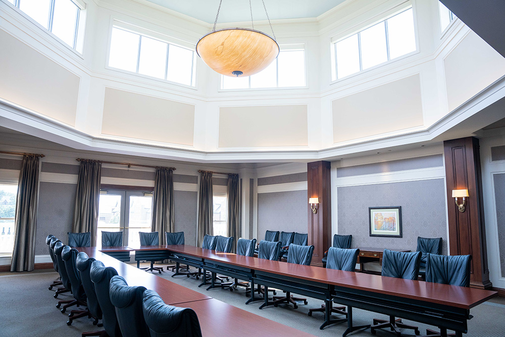 409 classroom with a table set up in a u shape and leather rolling chairs.