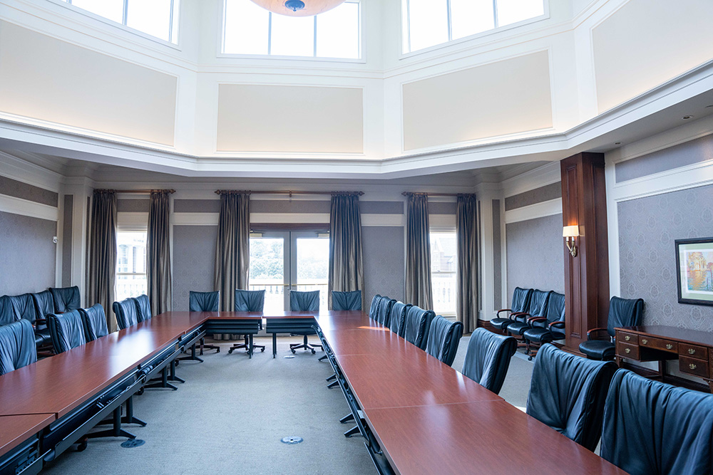 409 classroom with a table set up in a u shape and leather rolling chairs.