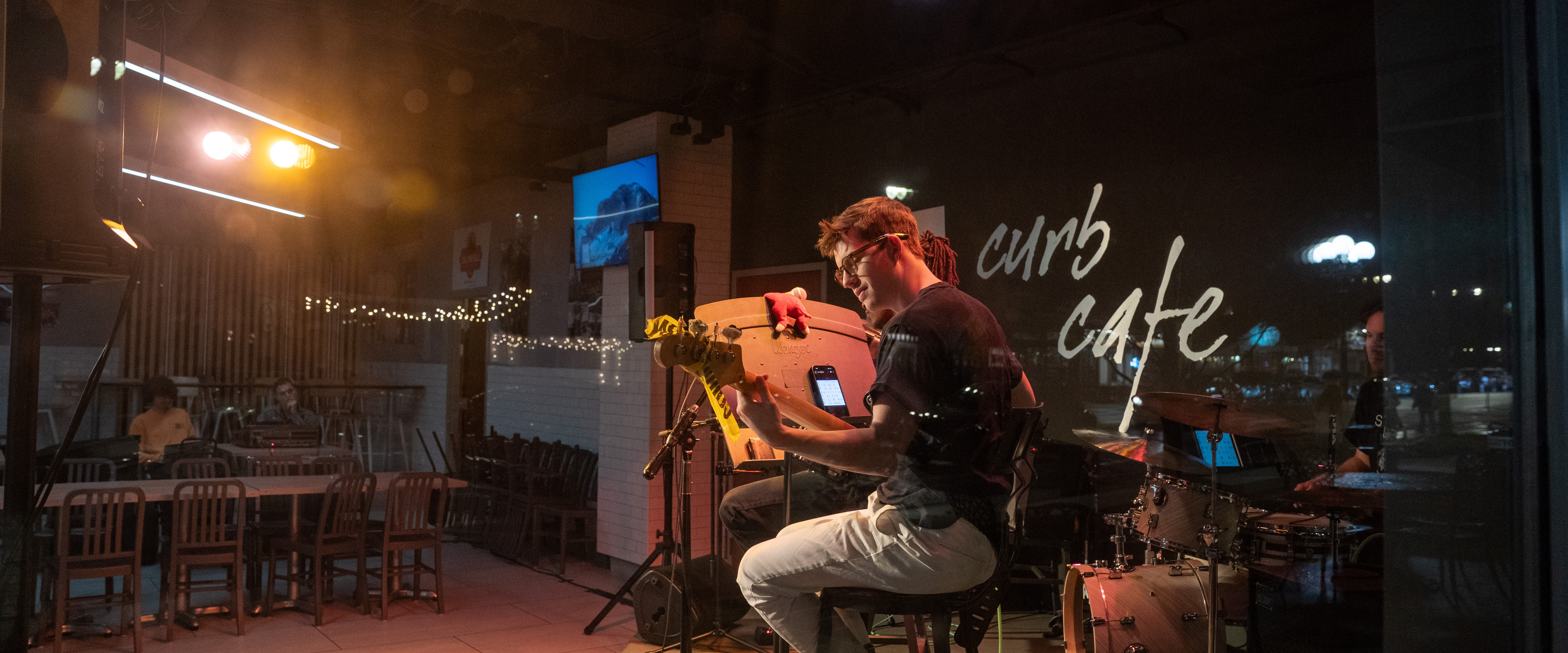 Students playing on stage in curb cafe at night