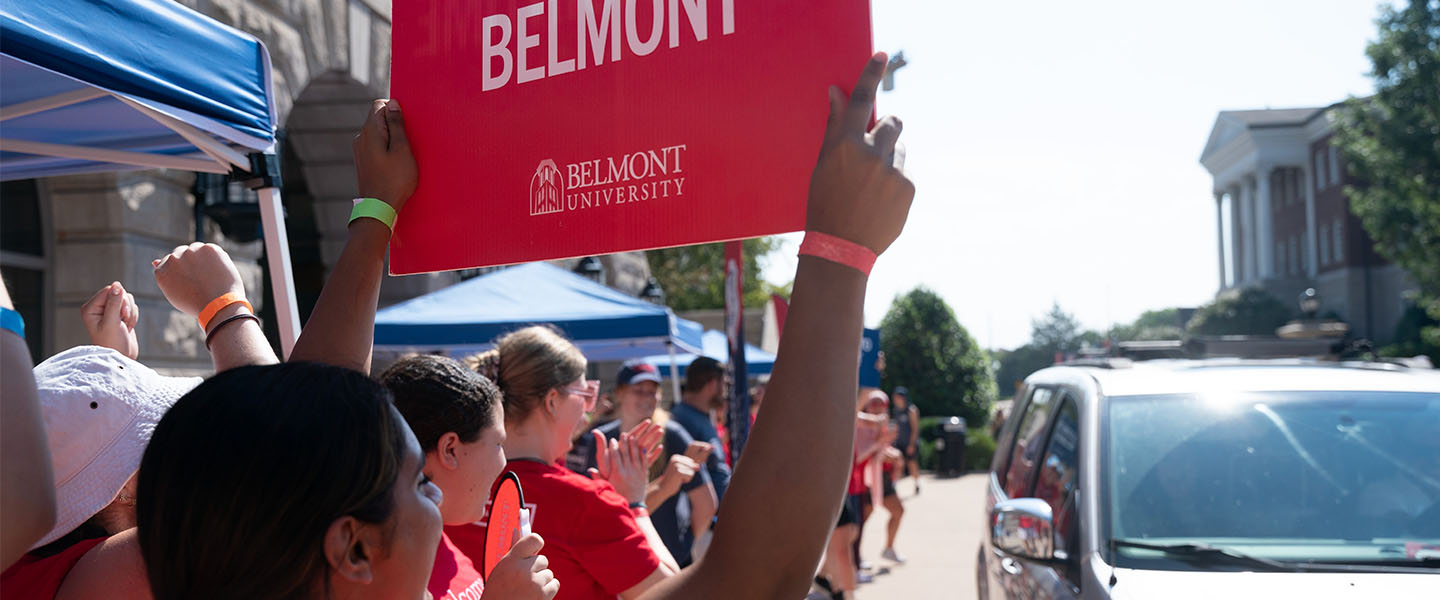 Students holding a Welcome to Belmont sign on move in day
