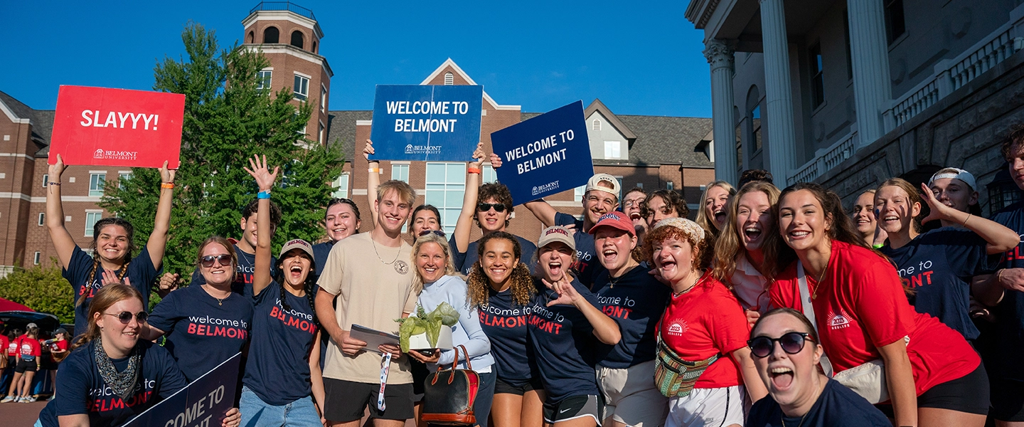 Belmont orientation leaders holding up signs welcoming new students to Belmont