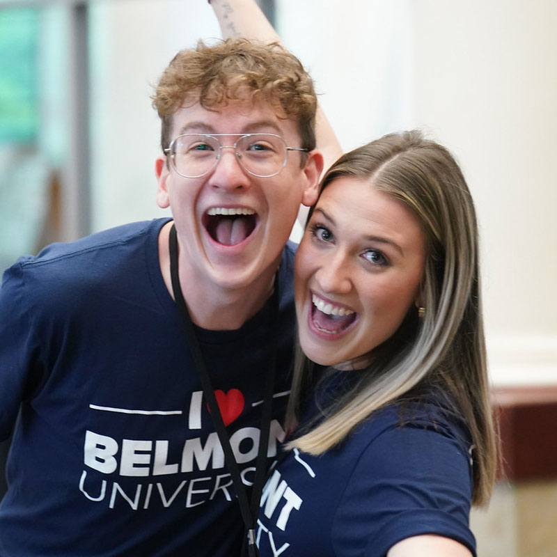 Two Orientation Leaders hugging and smiling happily