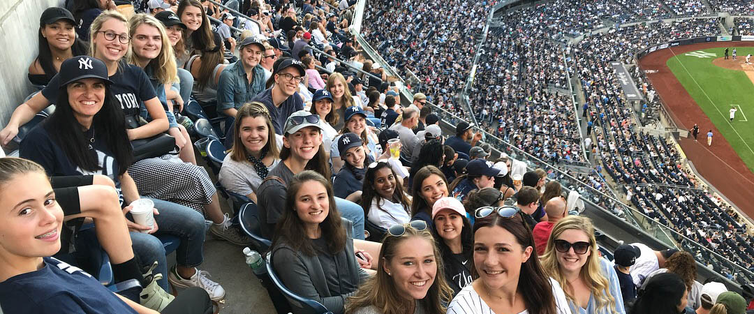 Belmont USA students smile for picture at baseball game