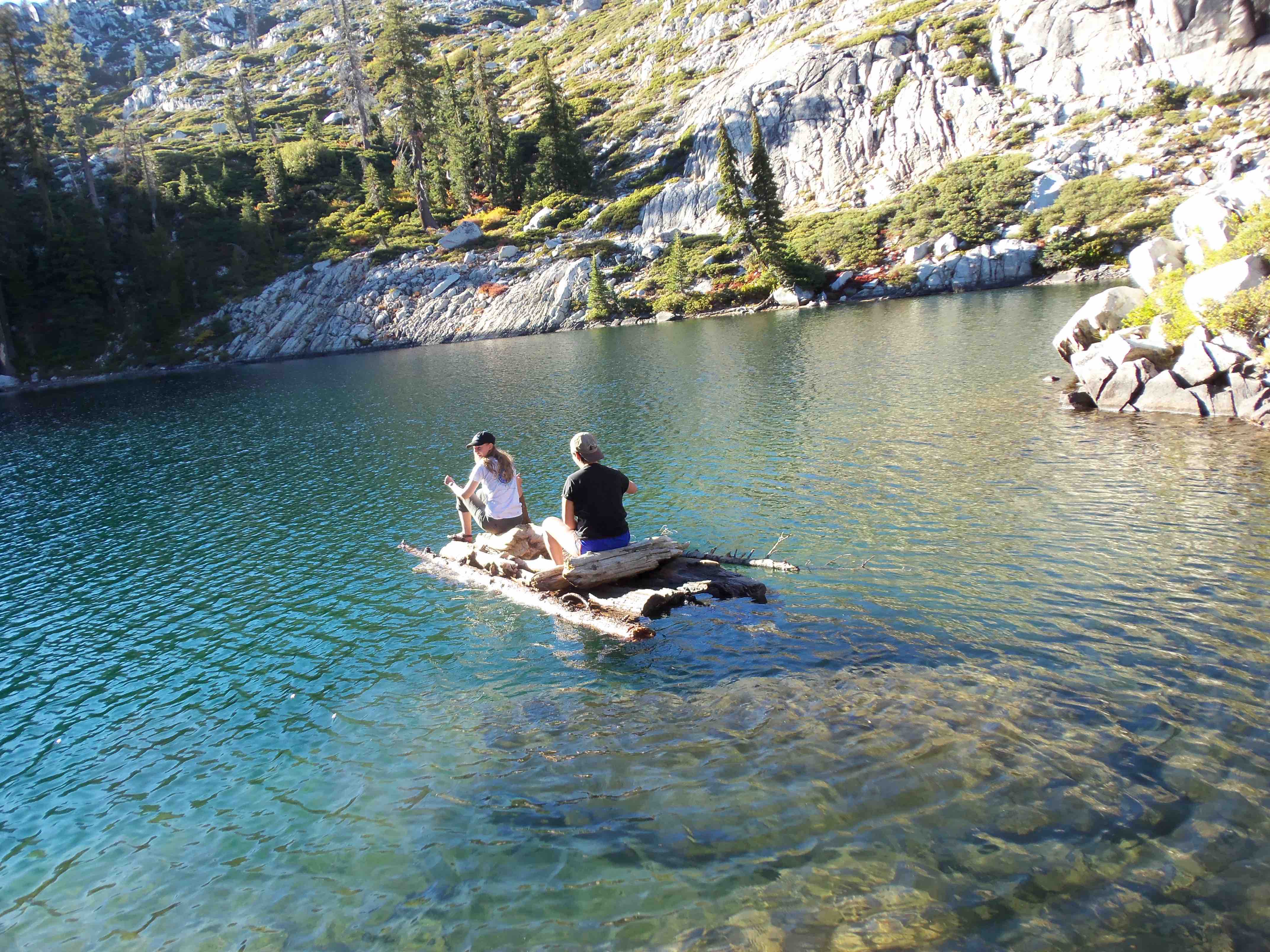 Belmont Oregon studnets ride on man made log boat on clear lake