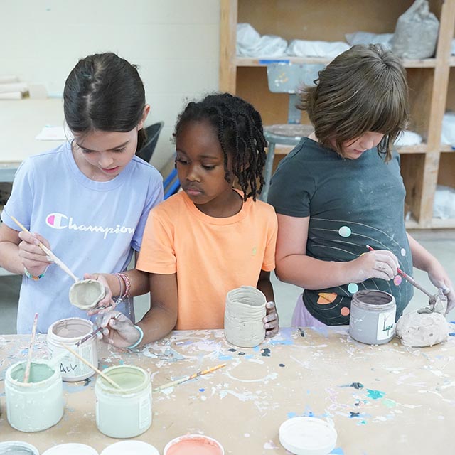 young art campers paint pottery in pottery studio