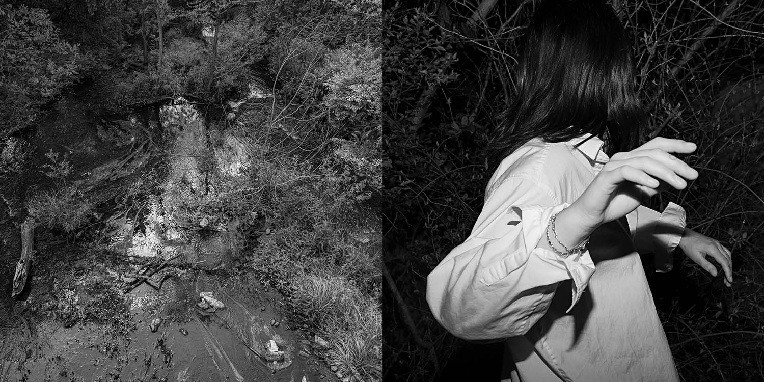 Black and white photo of back of girls black hair in woods at night