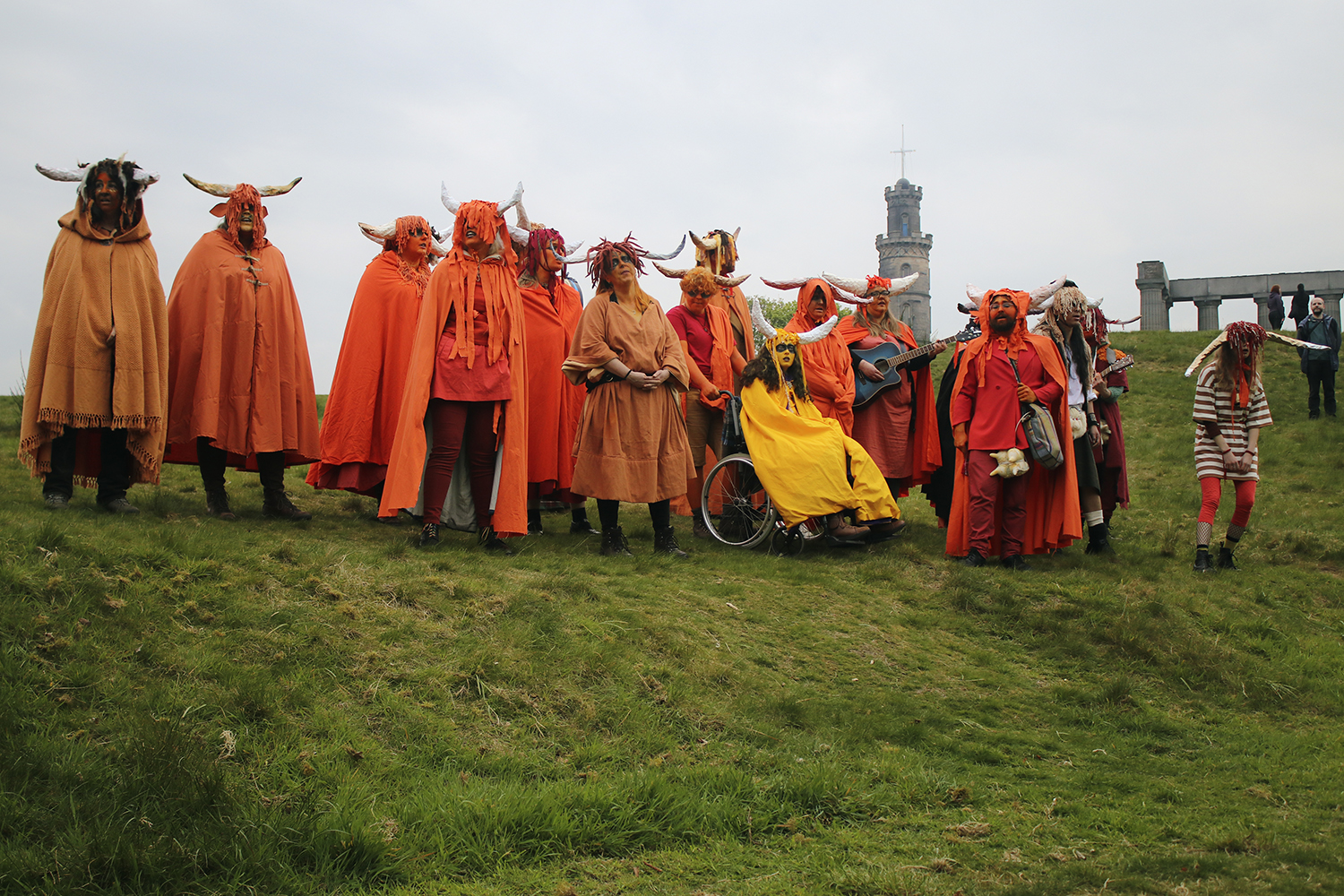 People wearing horn\ed helmets and bright orange capes